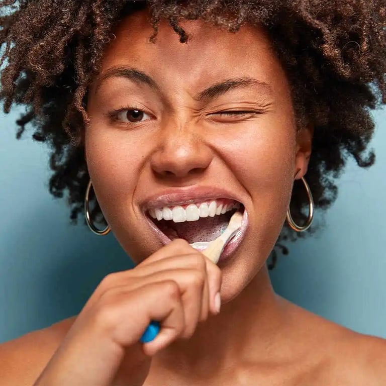 Woman brushing her teeth and smiling