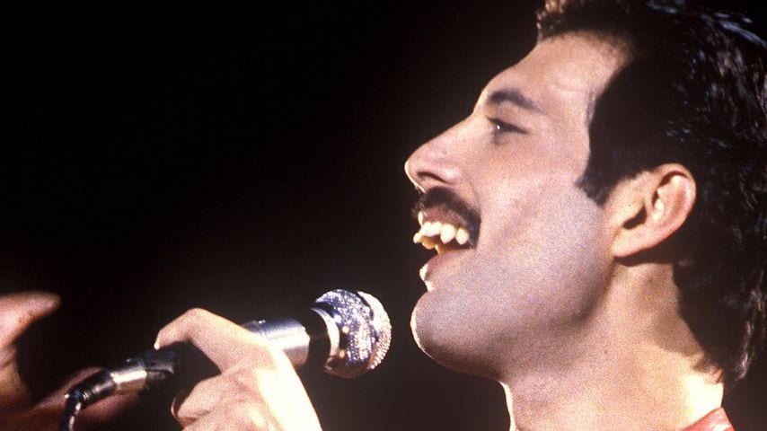 Freddie Mercury performing live showing his distinctive teeth and overjet profile